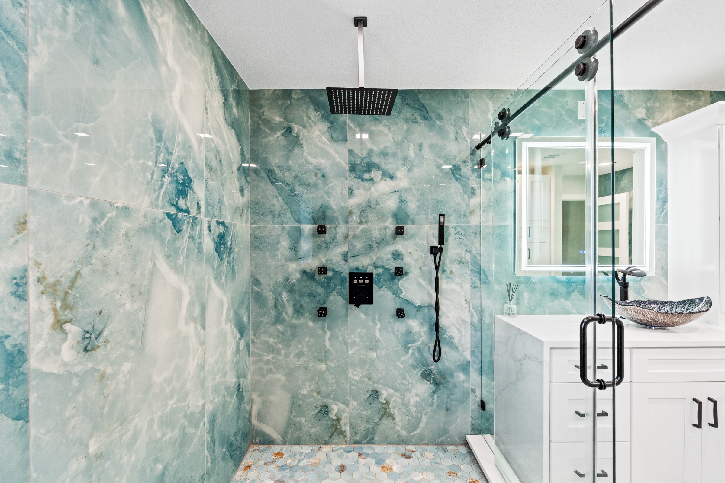 Luxury real estate photography Tampa FL — teal marble master shower with matte black fixtures