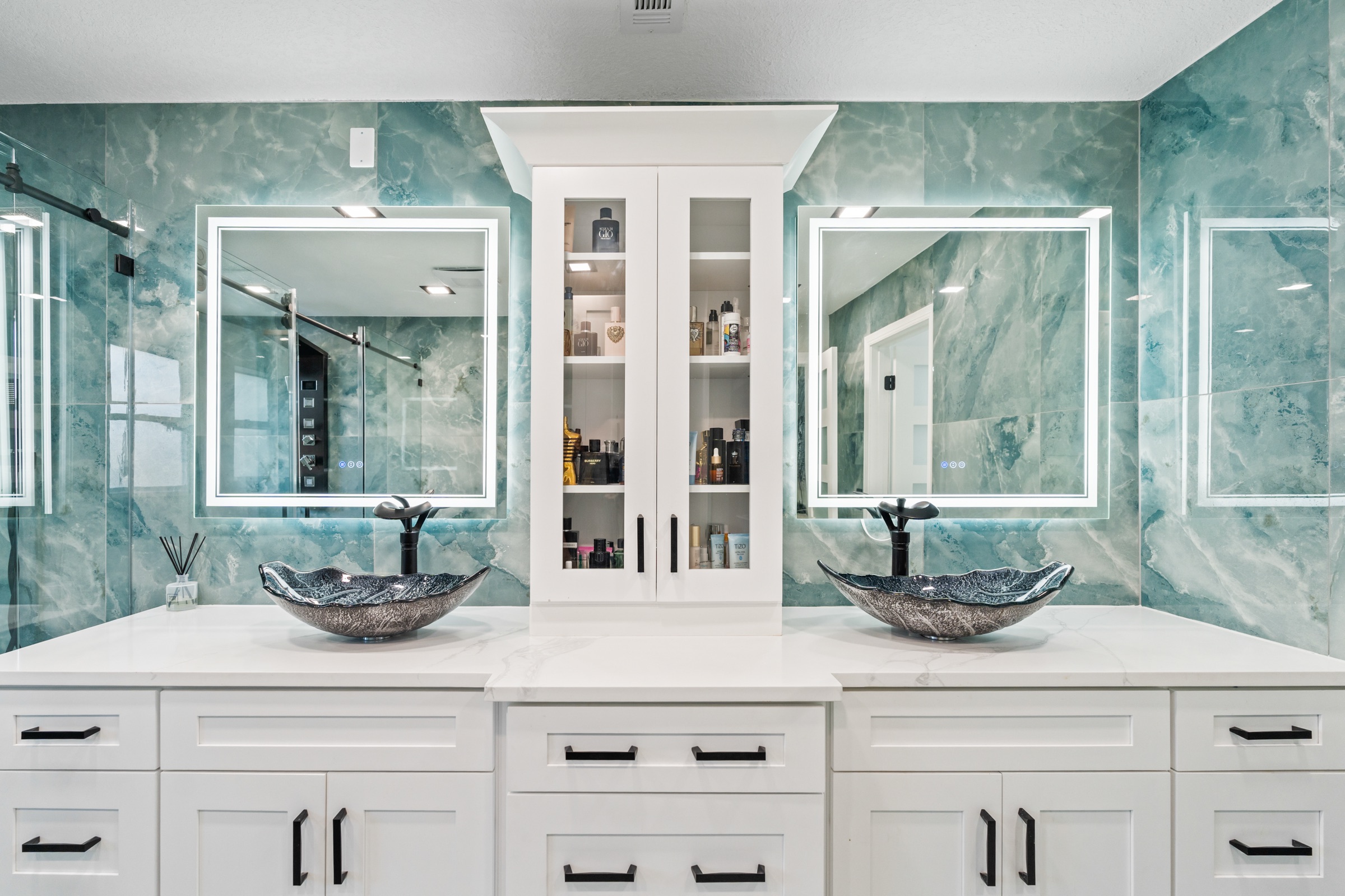 Luxury bathroom photography Tampa FL — double vanity with teal marble walls and backlit LED mirrors