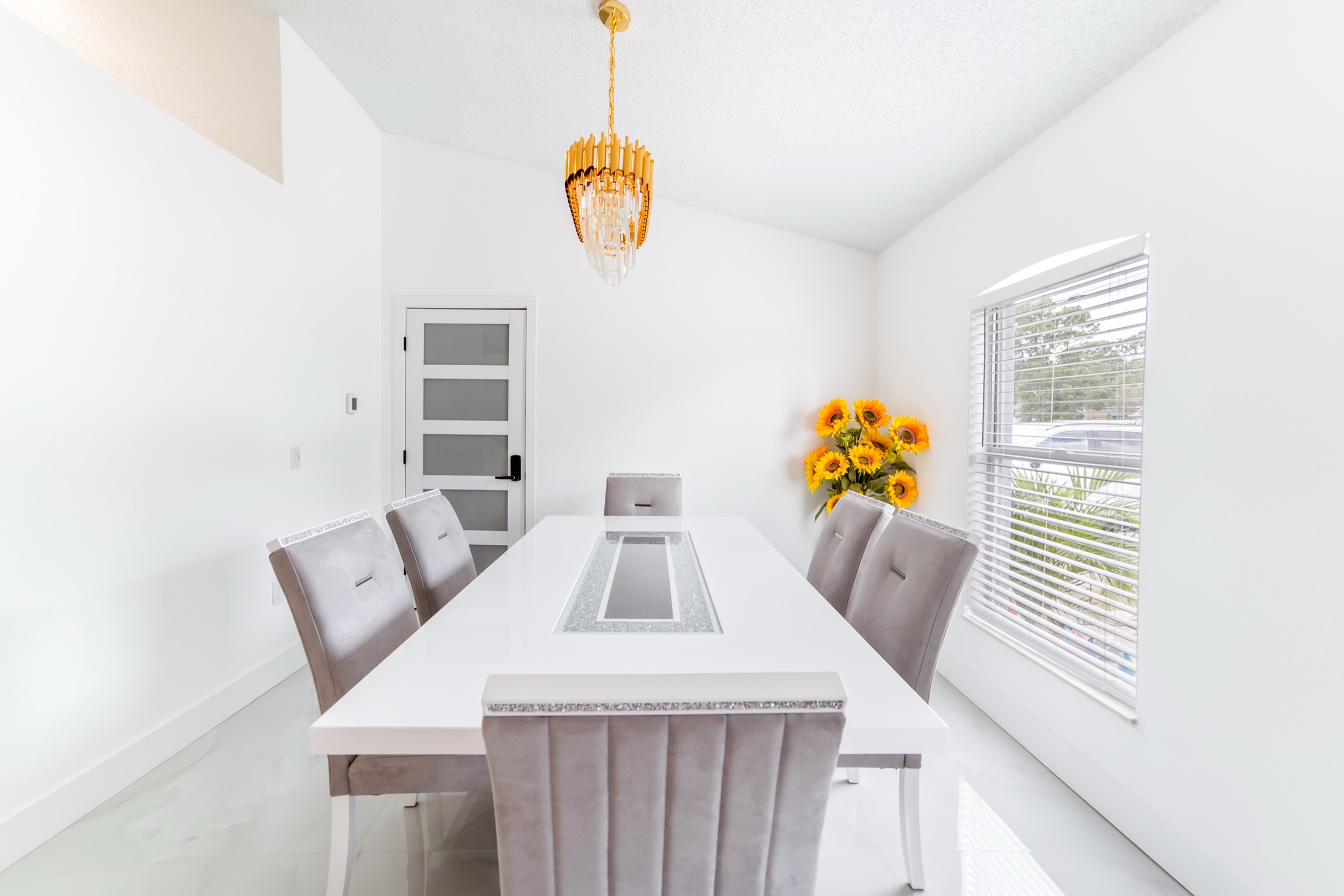 Real estate photography Tampa FL — elegant dining room with statement gold chandelier and fresh flowers