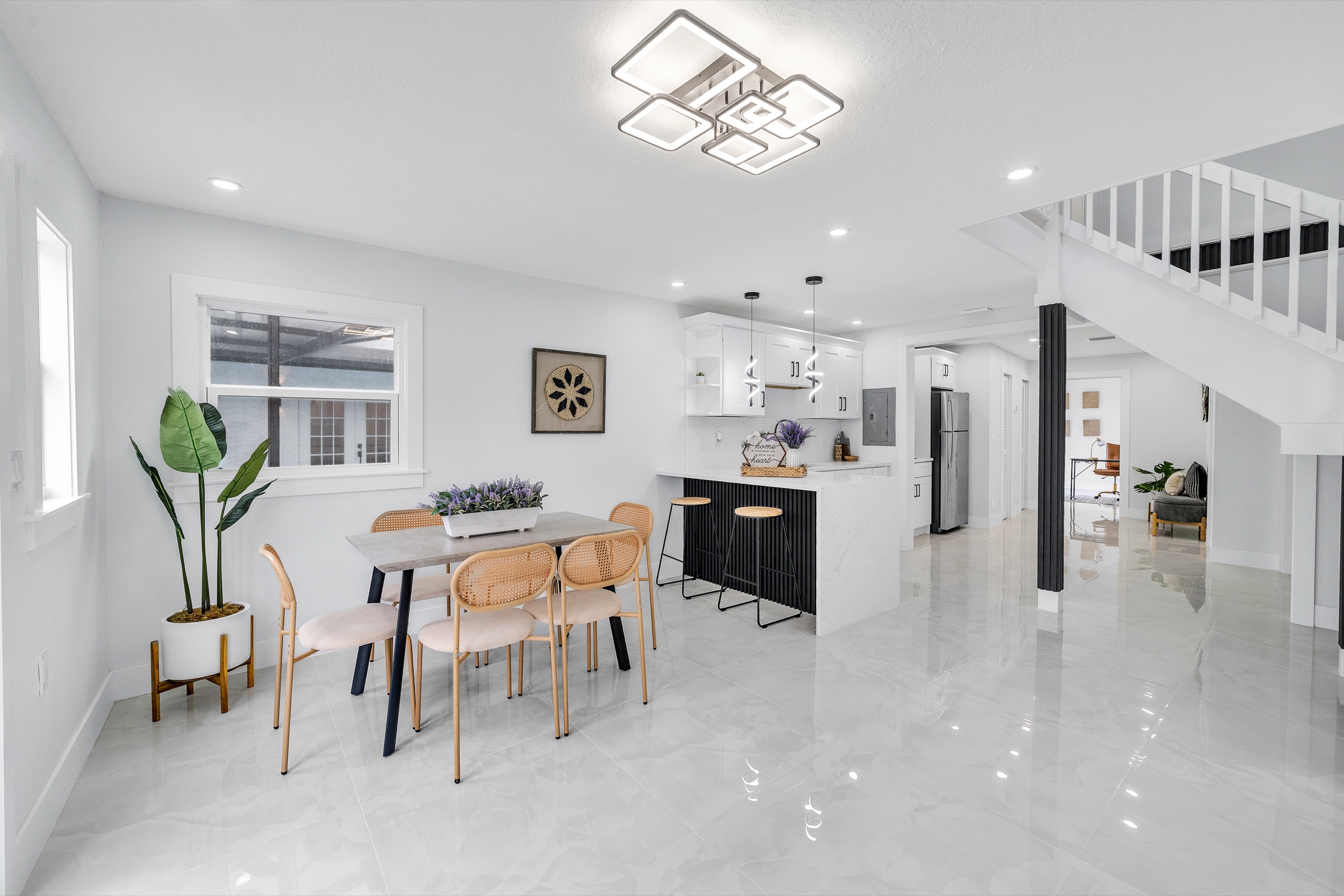Real estate photography Tampa FL — open plan dining room and kitchen with statement gold chandelier