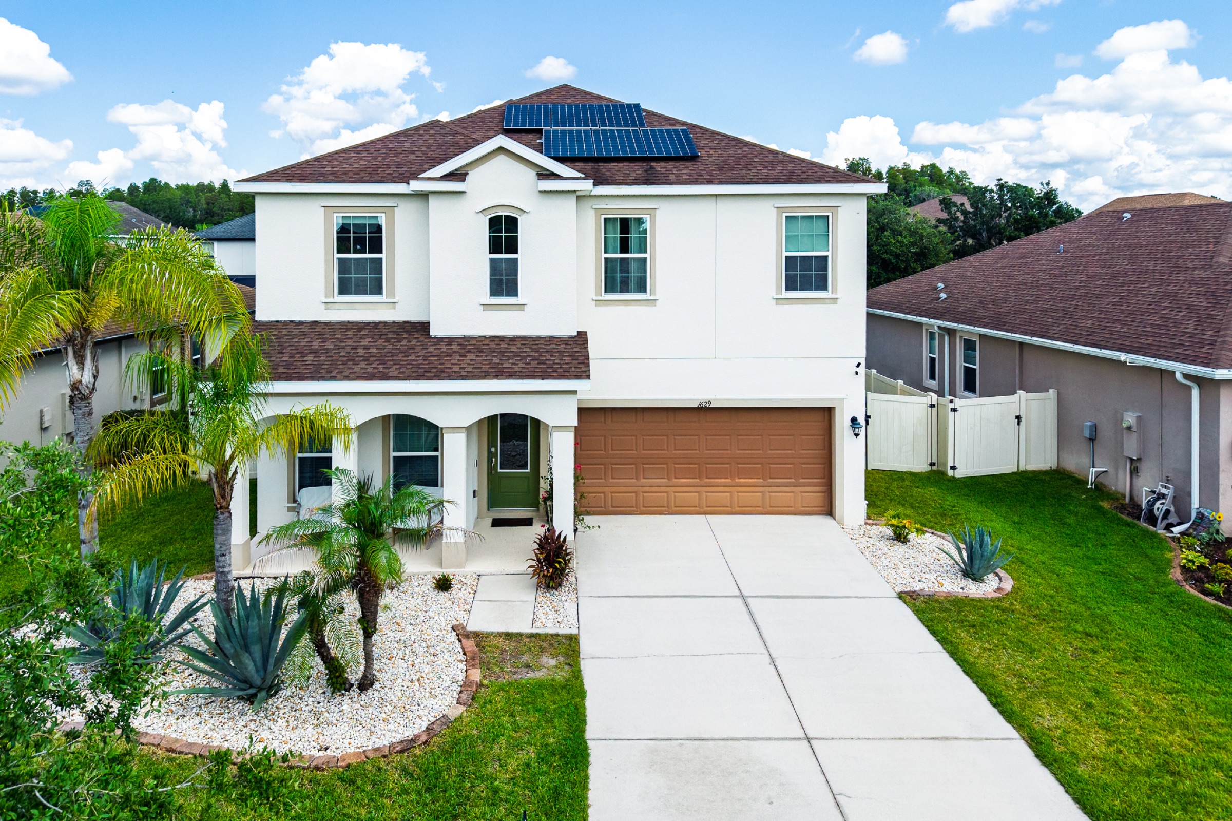 Real estate exterior photography Tampa FL — two-story home with palm trees and manicured landscaping