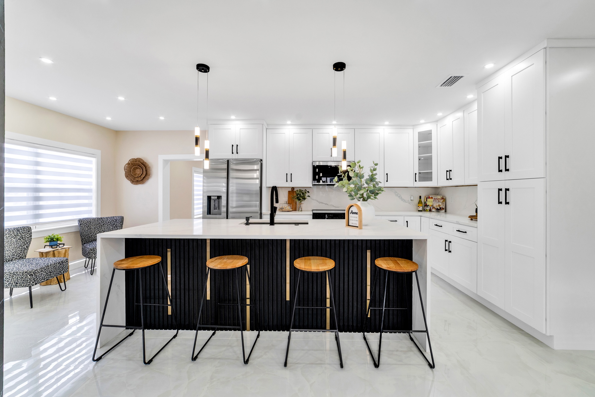Real estate listing photography Tampa — designer kitchen with black island, quartz counters, and wood bar stools