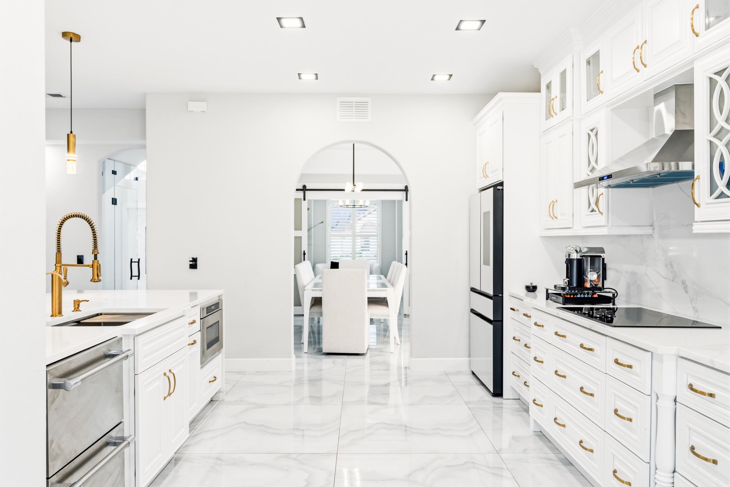 Luxury home kitchen photography Tampa — white cabinetry with gold hardware and arched details
