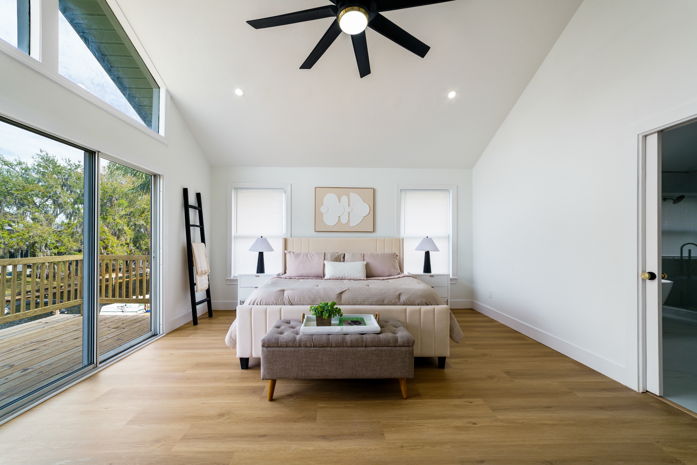 Real estate photography Tampa FL — master bedroom with vaulted ceiling, natural light, and private deck access