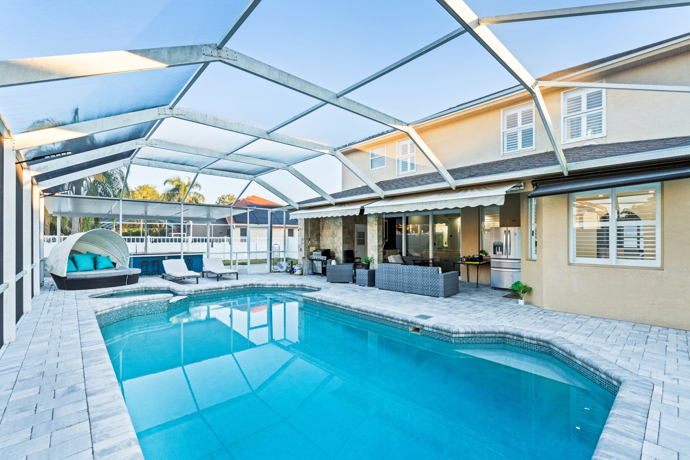Real estate outdoor photography Tampa FL — screened pool at golden hour sunset