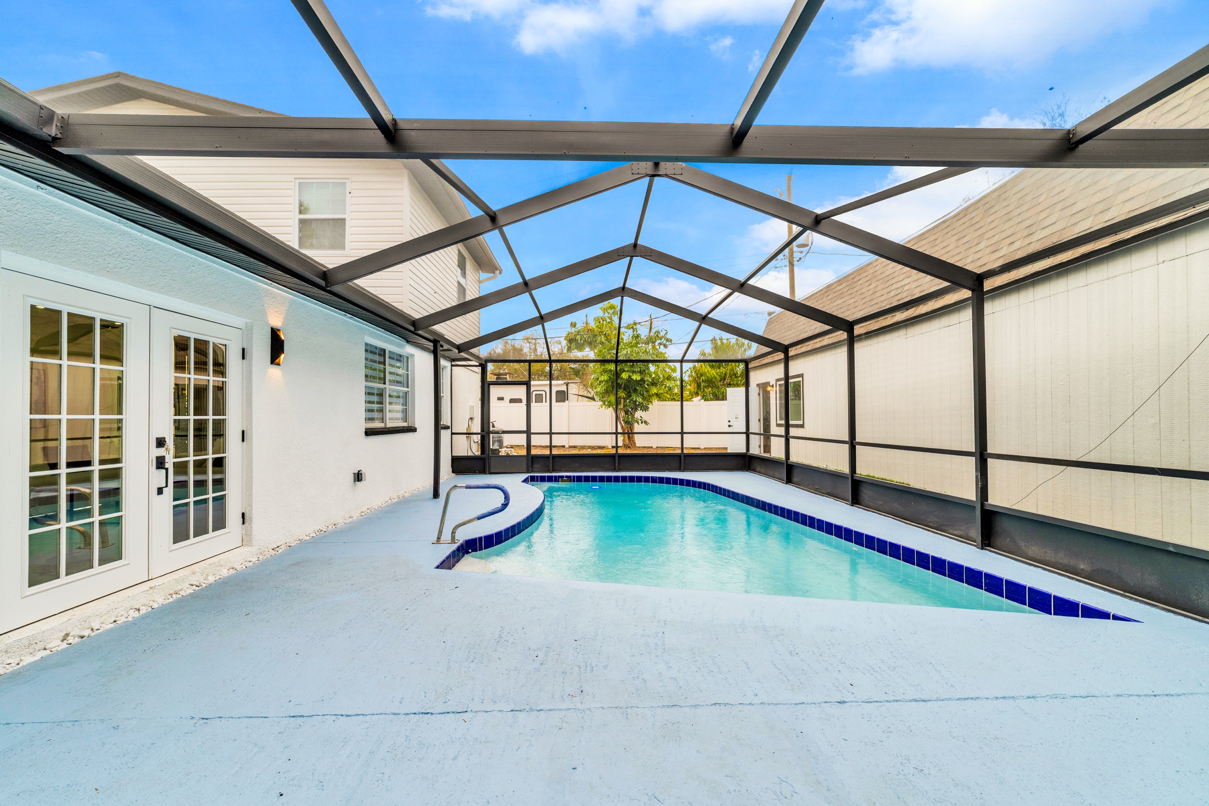 Real estate outdoor photography Tampa FL — Florida screened pool enclosure with blue water