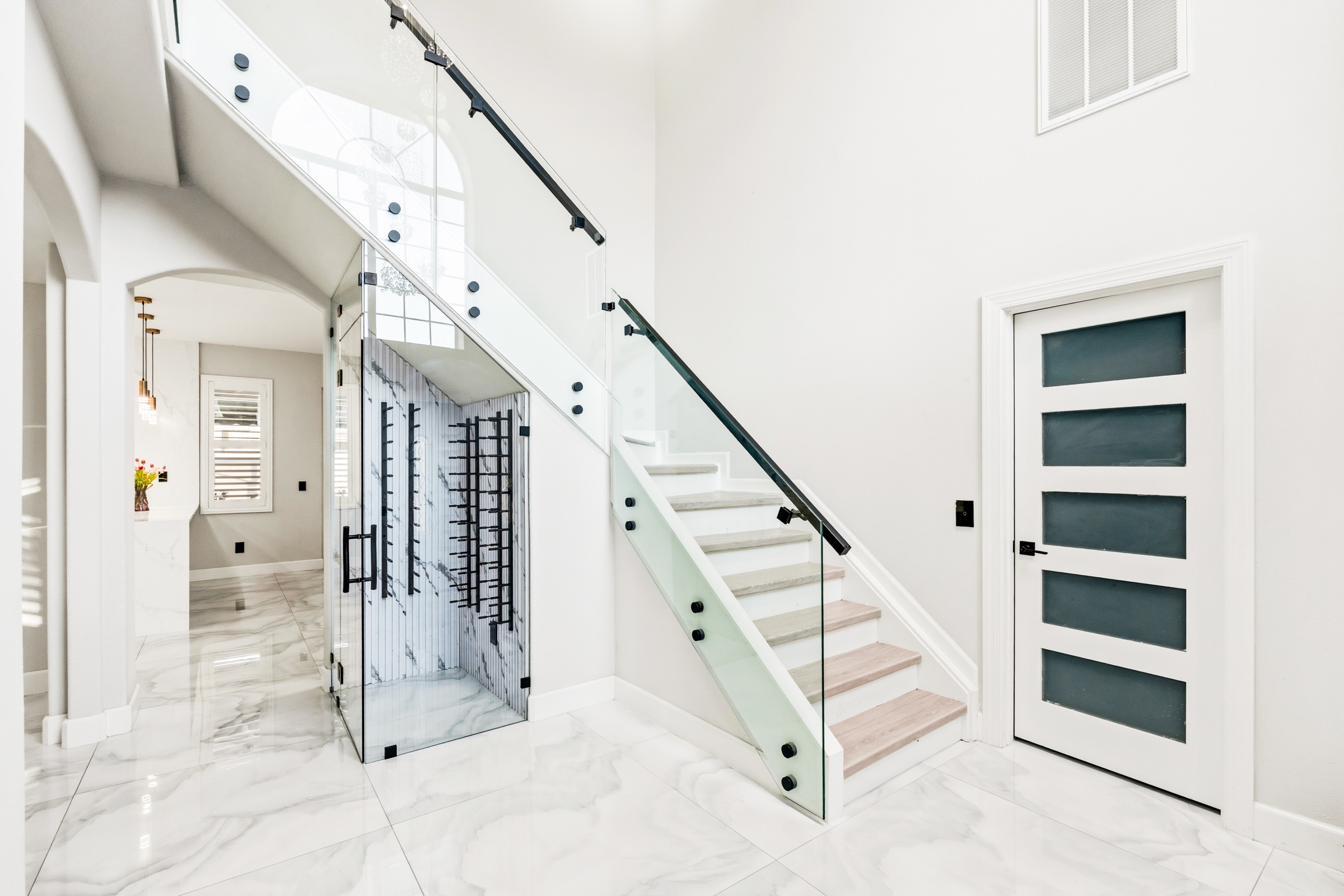 Luxury property photography Tampa — glass staircase with custom wine cellar beneath